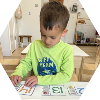 Preschool child practicing letter recognition with alphabet cards at Learning to Flourish.