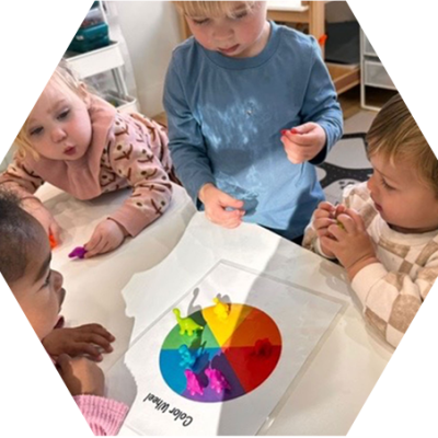 Preschool children exploring colors together with a hands-on color wheel activity.