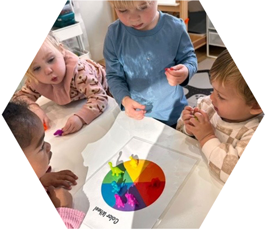 Preschool children exploring colors together with a hands-on color wheel activity.